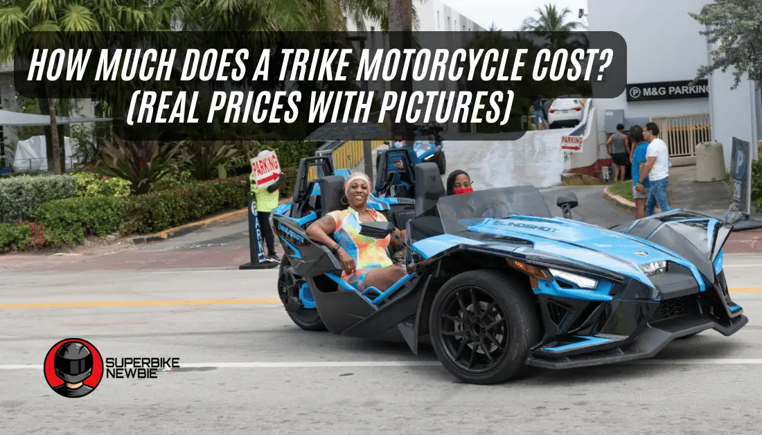 Two African American women seen driving in a blue Polaris Slingshot Trike Motorcycle. The passenger seems to be smiling and looking at the camera. The camera captures a side angle of the trike.