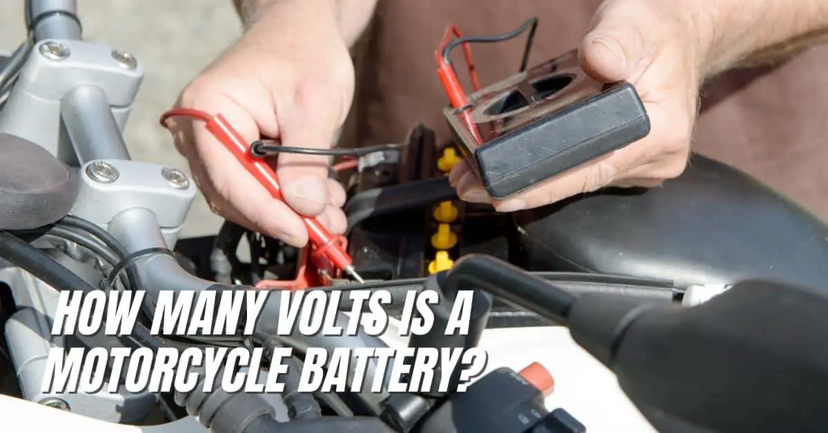 Close up of motorcycle rider checking the voltage of his motorcycle battery. The voltmeter cables are plugged in and he seems to be checking the voltage reading. Only his hands, the voltmeter, the motorcycle battery are seen.