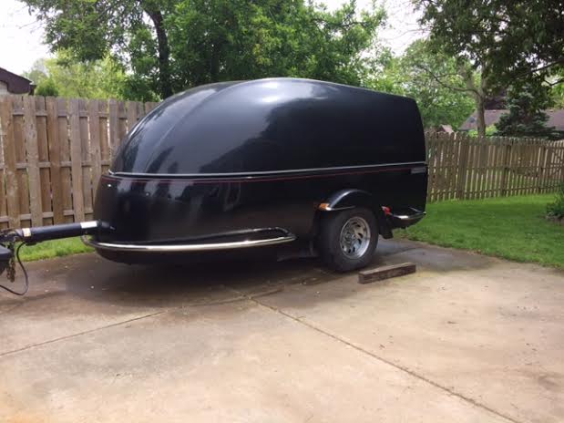 Black Colored Clamshell Motorcycle Trailer Parked in a backyard