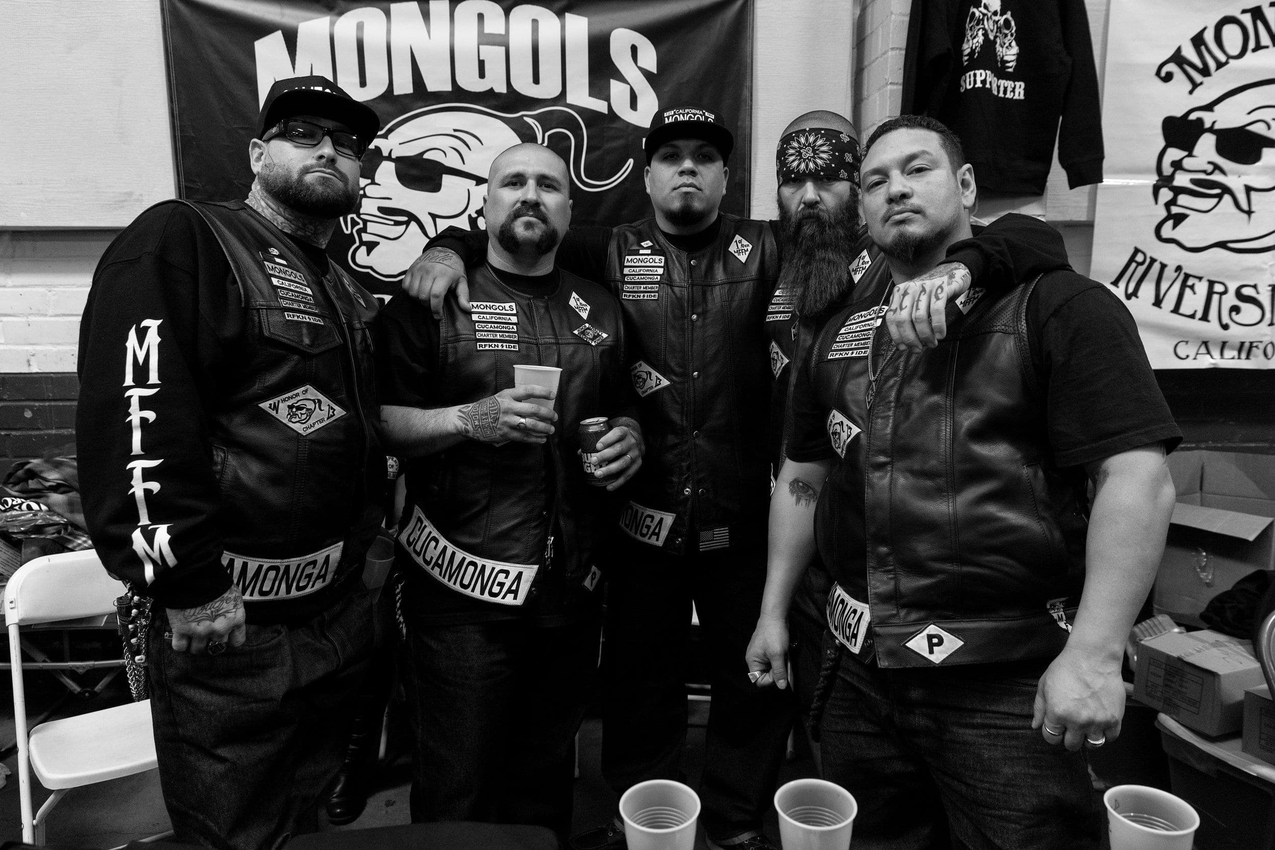 Mongols Motorcycle Club members posing in their clubhouse under the Mongols MC banner